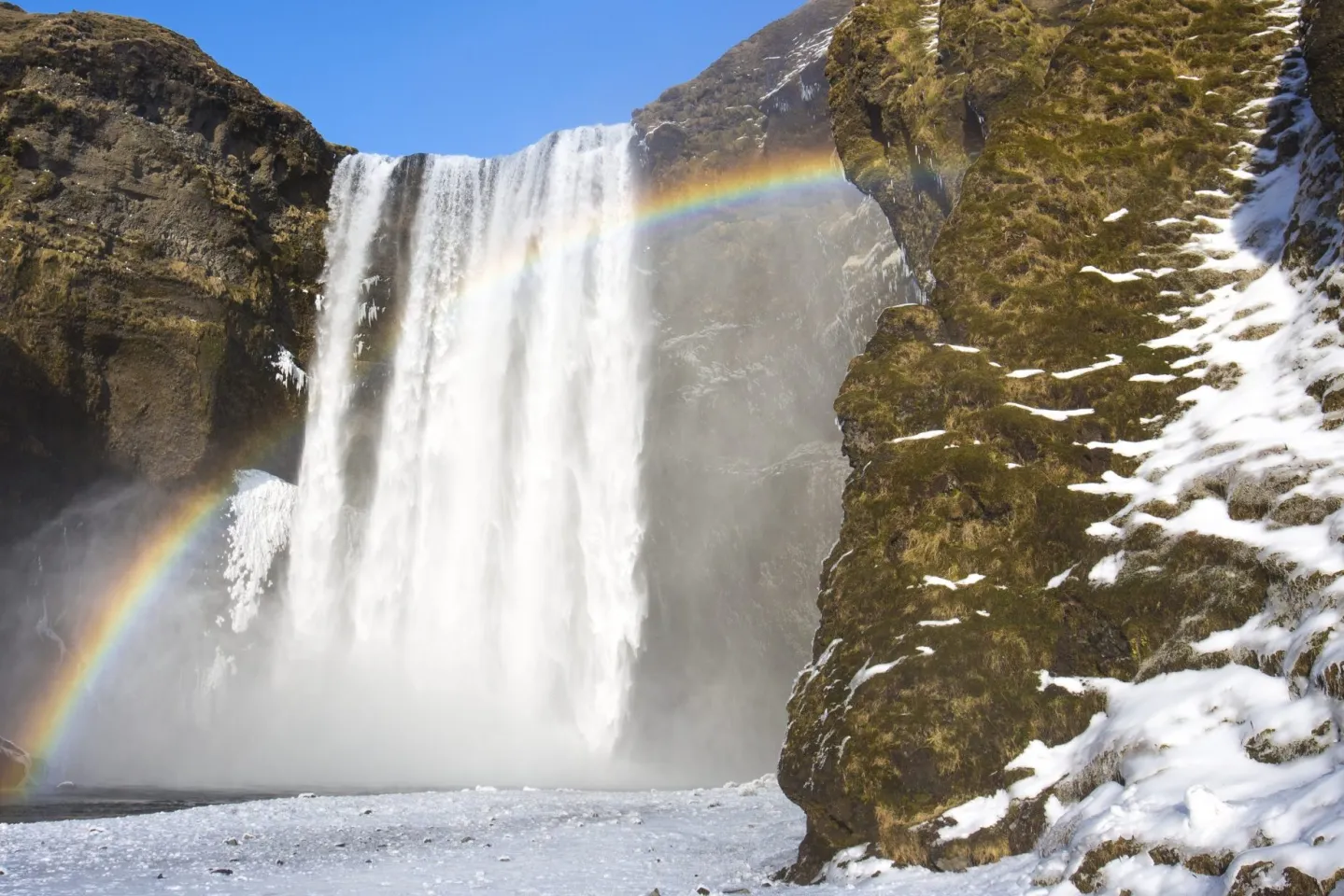 rainbow glistening by a waterfall