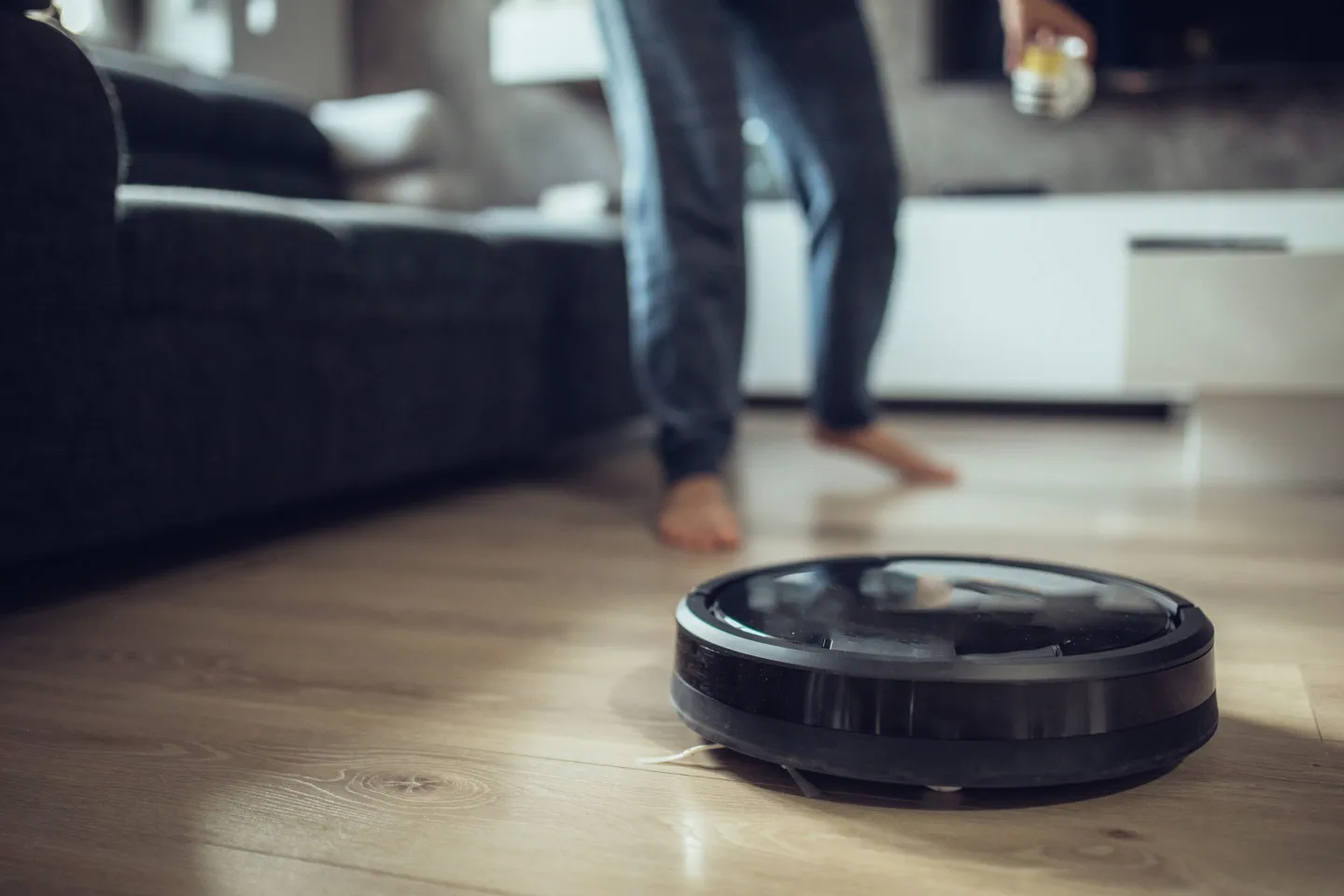 Man standing behind robot vacuum