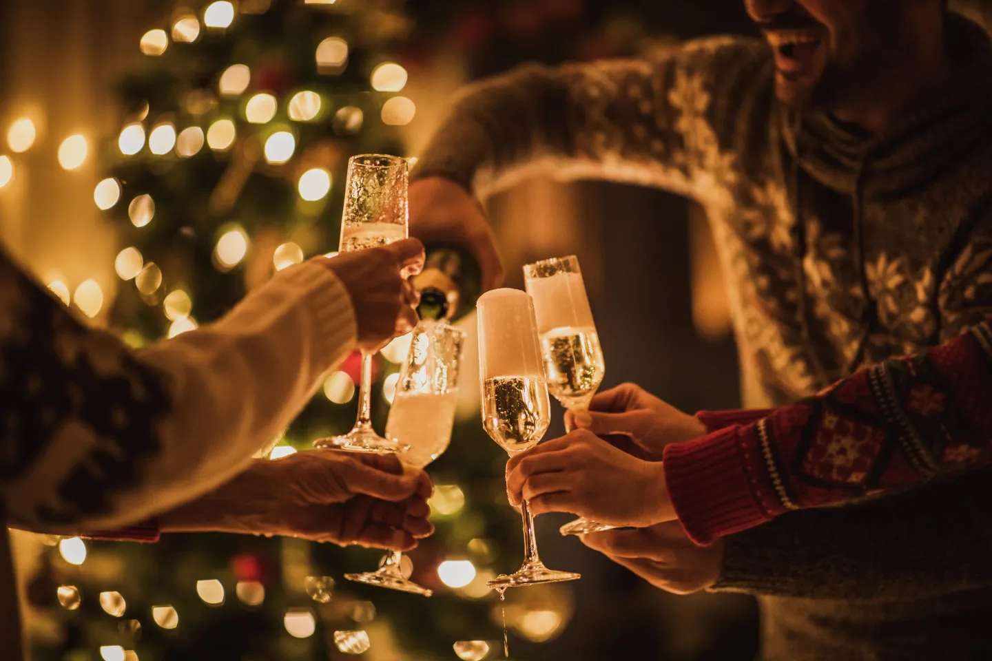 Group of people pouring Champagne into glasses