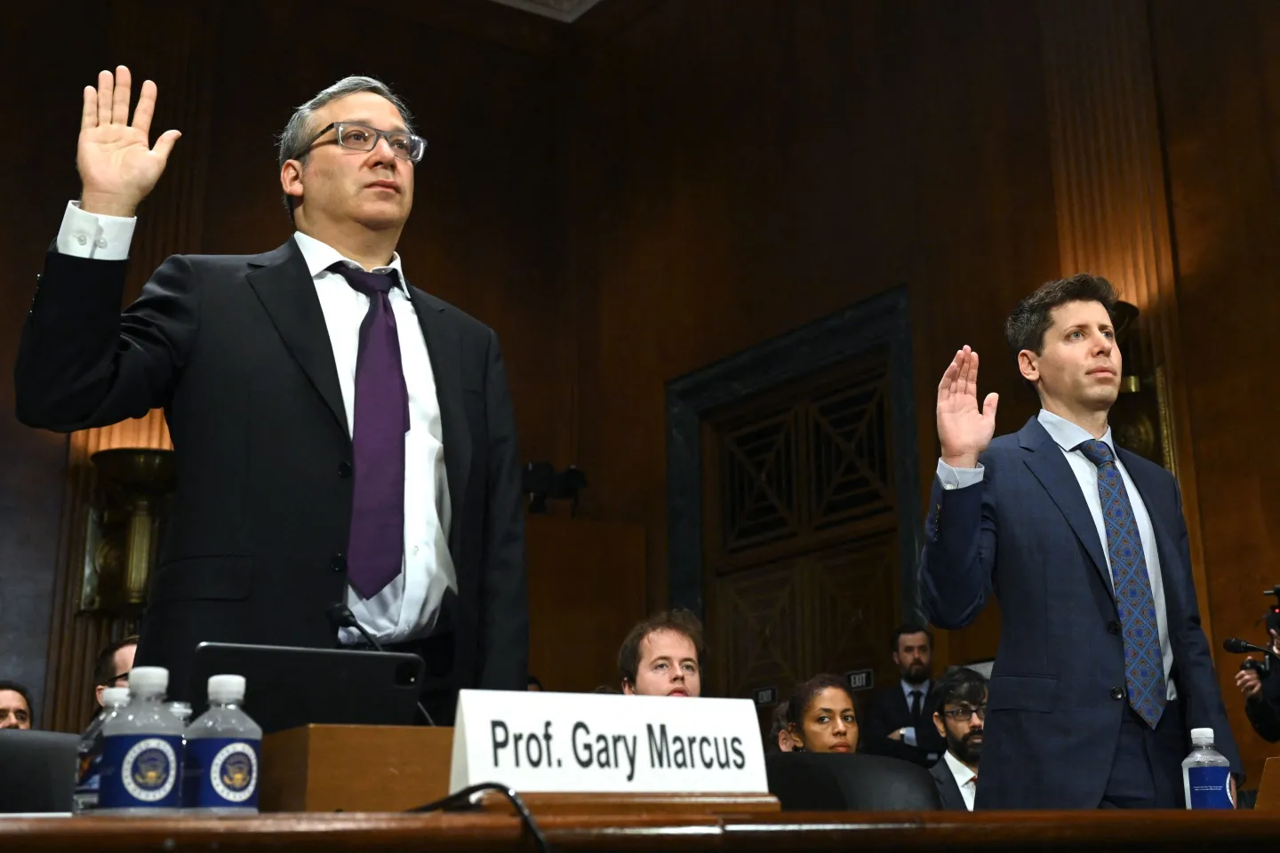 AI expert Gary Marcus and OpenAI CEO Sam Altman standing with their right hands raised as they are sworn in to testify before the U.S. Congress on AI's impact and potential regulation in May 2023.