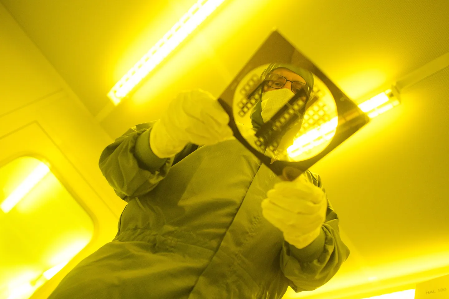 a man carries a mask for the production of semiconductor structures through the clean room