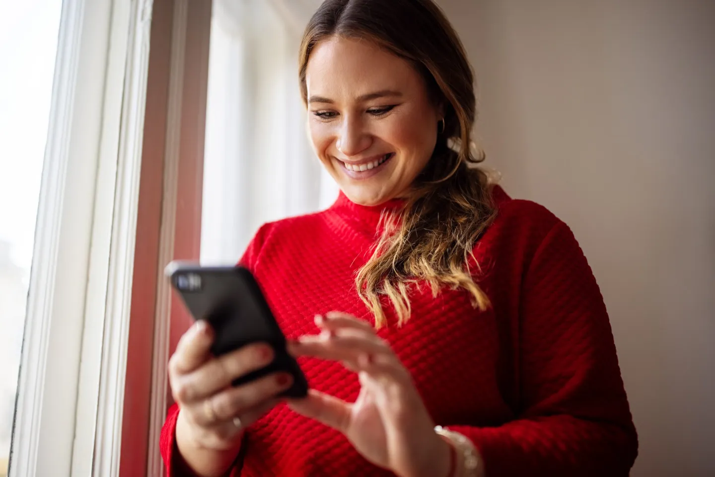 Woman texting on her smart phone and smiling