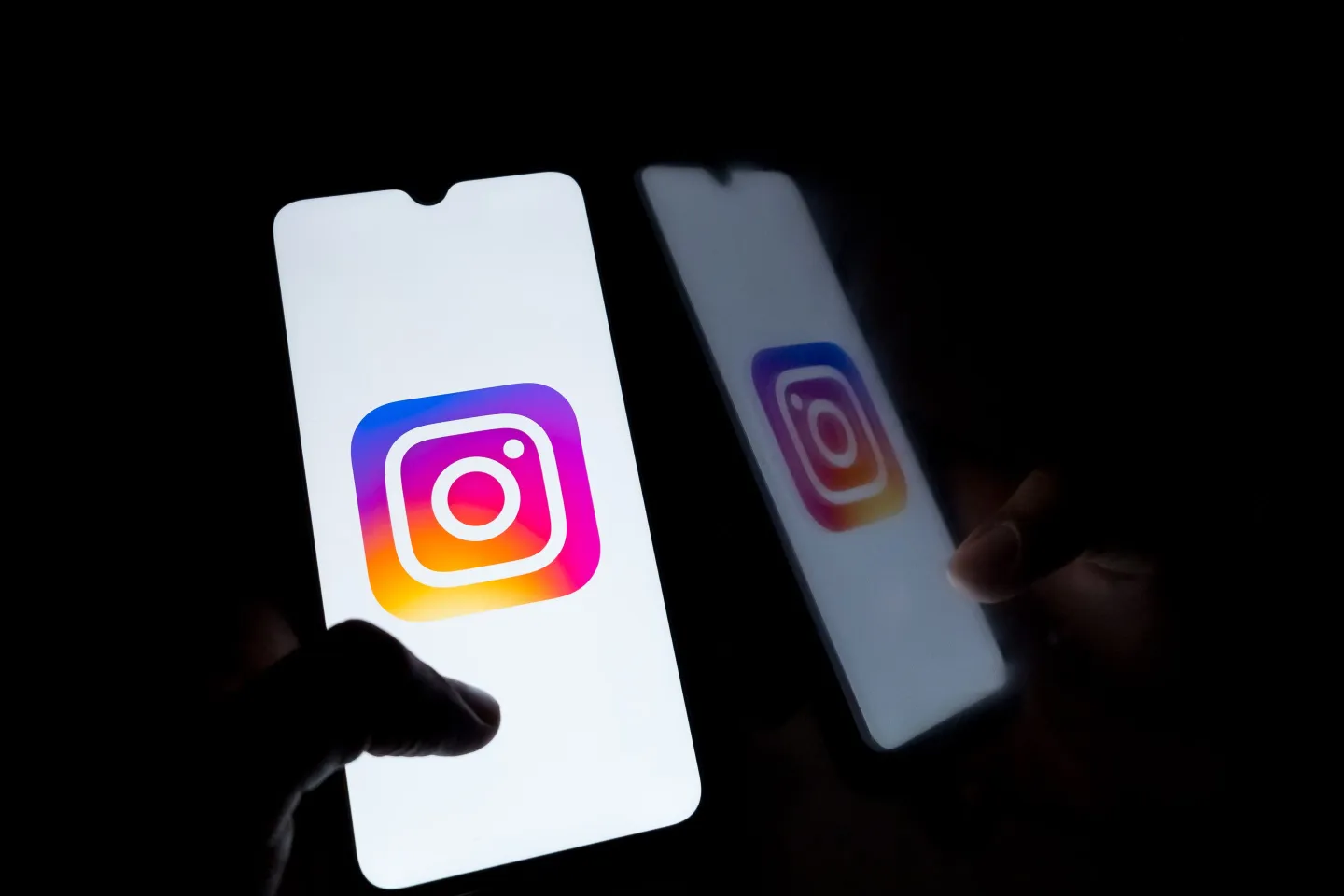 Instagram logo on smartphone screen against black background