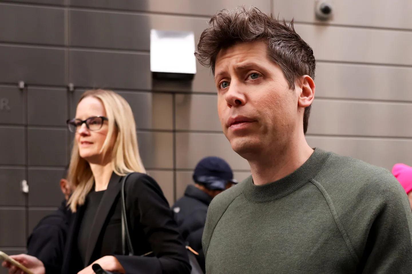 OpenAI CEO Sam Altman in a green sweater walking out of the New York Times DealBook Summit at Jazz at Lincoln Center in New York.