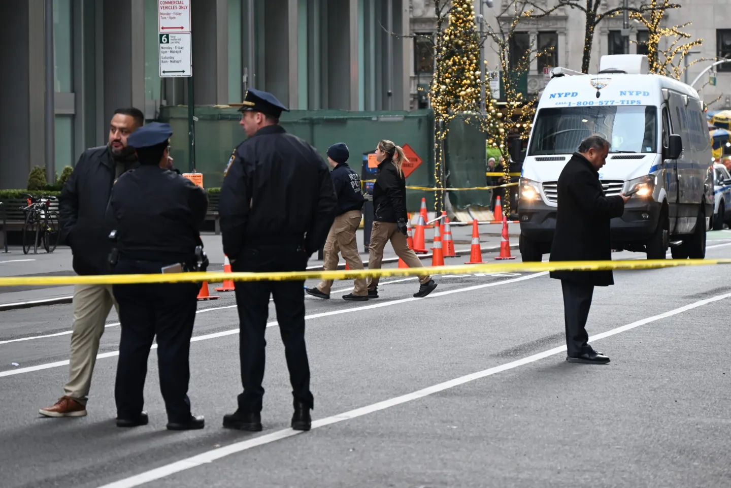 NYPD officers standing in the street behind caution tape