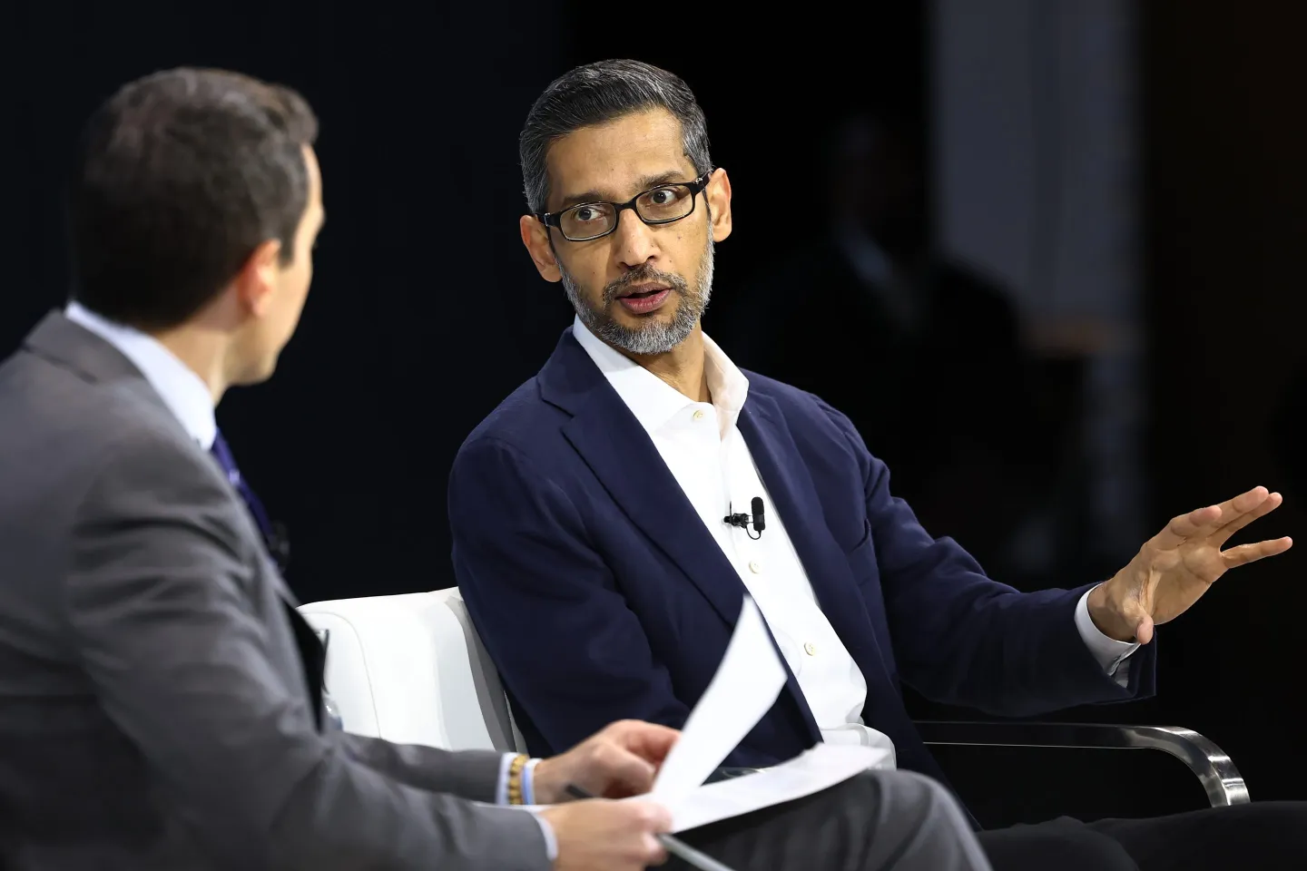 Alphabet CEO Sundar Pichai speaking on stage at a tech conference.