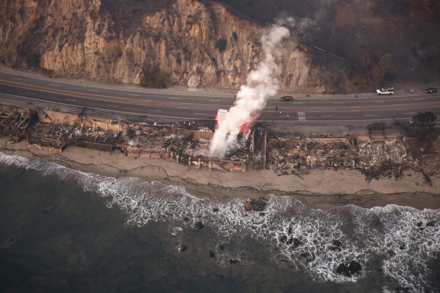 MALIBU, CALIFORNIA - JANUARY 09: In an aerial view, destroyed homes are seen along the beach as the Palisades Fire continues to burn on January 09, 2025 in Malibu, California. Multiple wildfires fueled by intense Santa Ana Winds are burning across Los Angeles County. At least five people have been killed, and over 25,000 acres have burned. Over 2,000 structures have also burned and almost 180,000 people are under orders to evacuate. (Photo by Mario Tama/Getty Images)