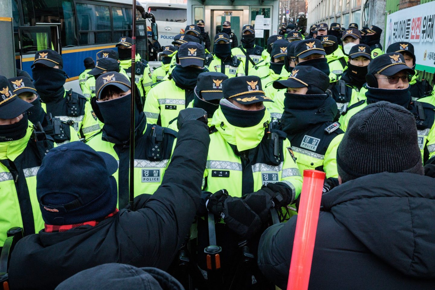 Police officers stand at the barricade with supporters of impeached South Korean President Yoon Suk Yeol as authorities try to detain him near his residence in Seoul on January 15, 2025. Yoon was arrested on January 15 over his failed martial law bid, after hundreds of anti-graft investigators and police raided his residence to end a weeks-long standoff. (Photo by YASUYOSHI CHIBA / AFP) (Photo by YASUYOSHI CHIBA/AFP via Getty Images)