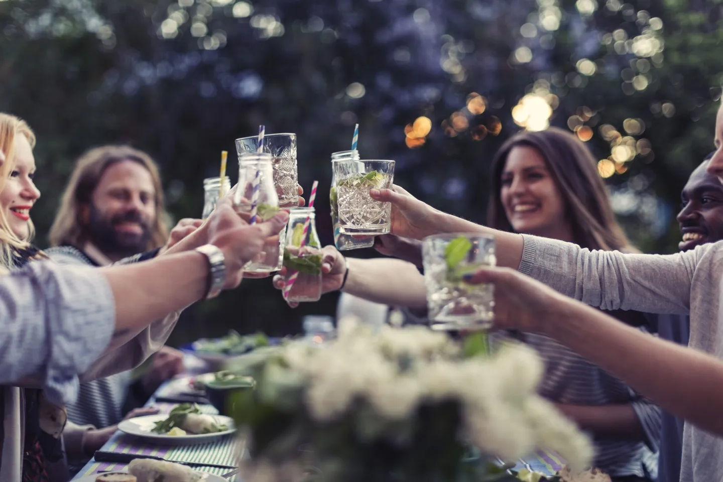 group of friends toasting with alcohol at an outdoor table