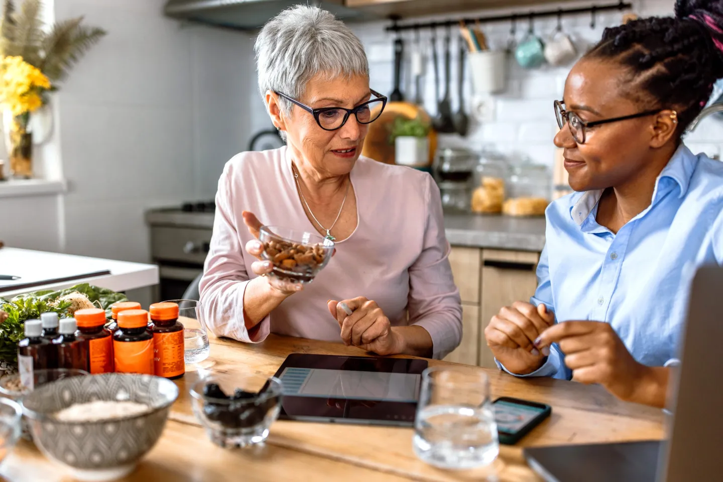 A nutritionist teaches client while holding a bowl of nuts.