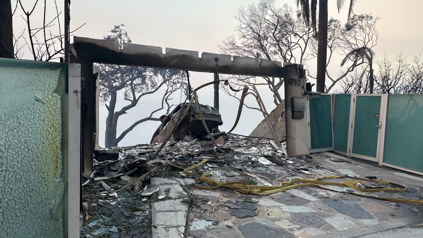 the frame of a garage and a car burnt by fire