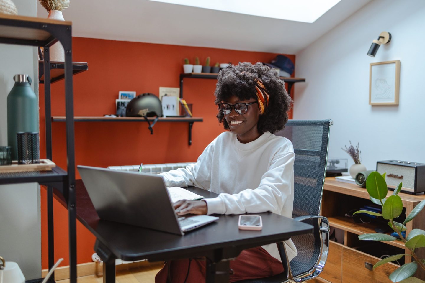 Young woman working remotely in a stylish home office setting.